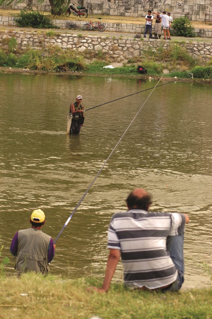 Taş Köprü'nün altından geçen Vardar nehrinde balıkçılar balık tutarken